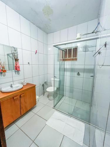 a bathroom with a glass shower and a toilet at Ótima casa no centro de Carrancas in Carrancas