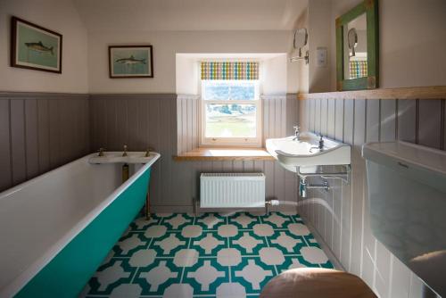 a bathroom with a tub and a sink and a bath tub at Keeper's Cottage, Straloch Estate in Perth