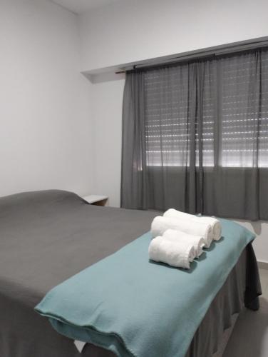 - une chambre avec un lit et des serviettes dans l'établissement AMPLIO DEPARTAMENTO CENTRICO TODO INCLUIDO 4b, à San Nicolás de los Arroyos