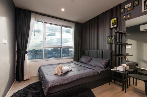 una camera con un letto e una grande finestra di NEW-Luxury 1BR Apartment Riverview-Netflix-MRT Sleeping couch a Ban Bang Phlat