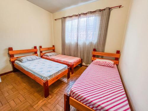 カランカスにあるÓtima casa no centro de Carrancasのベッド2台と窓が備わる客室です。