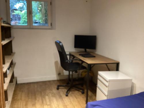 een kamer met een bureau met een computer en een stoel bij Chambres en maison in Fontenay-sous-Bois