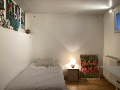 een kleine slaapkamer met een bed en een lamp bij Chambres en maison in Fontenay-sous-Bois