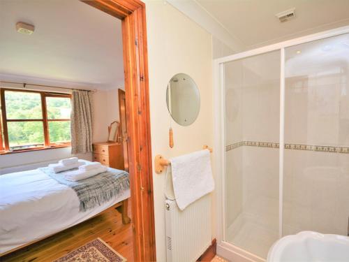 a bathroom with a shower and a bed in a room at 1 bed in Looe NUTHA in Warleggan