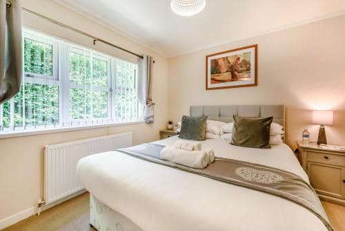 - une chambre avec un grand lit blanc et une fenêtre dans l'établissement HB Hornbeam Lodge 03, à Narberth