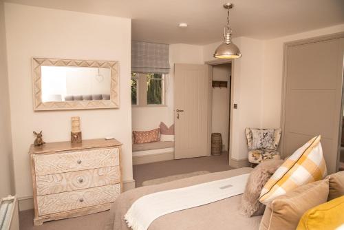 a bedroom with a bed and a dresser and a mirror at No.3 The Old Coach House in Blockley