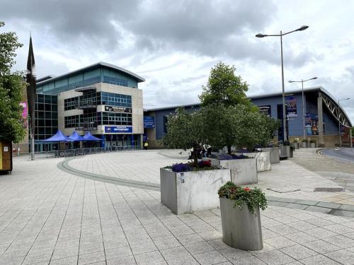 a large building with a courtyard with flowers and trees at National Arena, free Parking in Nottingham