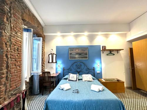 a bedroom with a blue bed with towels on it at The Vernazza Main Plaza - Rooms & Apartment in Vernazza
