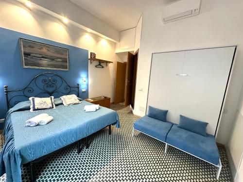 a blue bedroom with a bed and a blue couch at The Vernazza Main Plaza - Rooms & Apartment in Vernazza