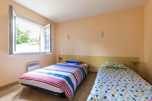 1 dormitorio con 2 camas y ventana en Vacances apaisantes au coeur du Bassin d Arcachon en Lanton