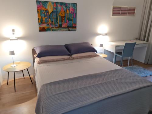 a bedroom with a bed and two tables and a desk at Elegante appartamento con vista a Cavallino Venezia in Cavallino-Treporti