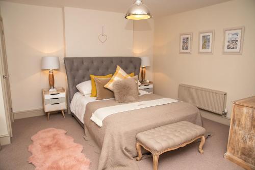 a bedroom with a large bed and a rug at No.3 The Old Coach House in Blockley
