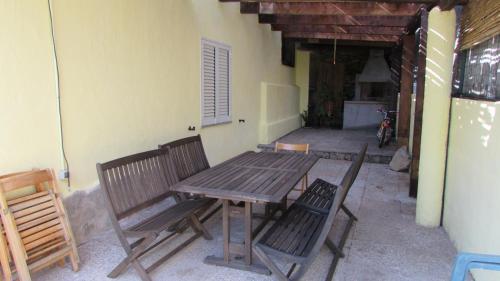 Une table et des chaises en bois sont disponibles sur la terrasse. dans l'établissement Villa dei Narcisi, à Solanas