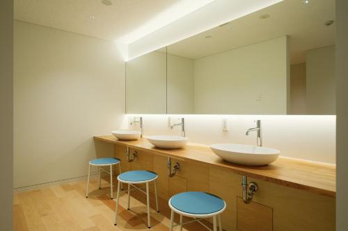 a bathroom with two sinks and two blue stools at BONAPOOL in Onomichi