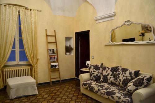 a living room with a couch and a mirror at Appartamento Ligure nel centro storico in Finale Ligure