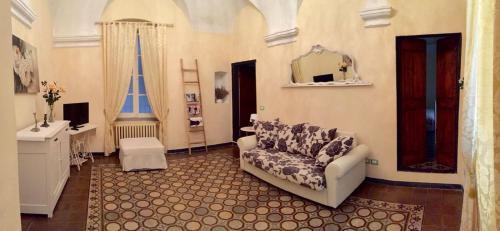 a living room with a couch and a mirror at Appartamento Ligure nel centro storico in Finale Ligure