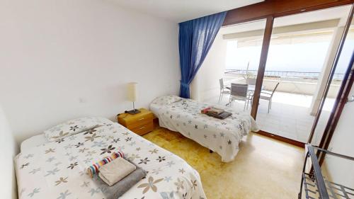 ein Schlafzimmer mit zwei Betten und einem Balkon in der Unterkunft Fine Duplex Apartment with Stunning Sea Views in Marbella