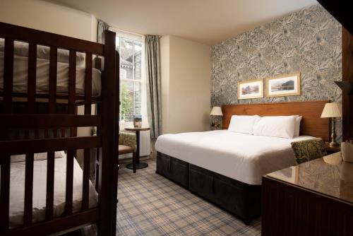 a hotel room with a bed and a staircase at The Temperance Inn, Ambleside - The Inn Collection Group in Ambleside