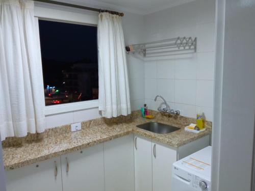 a kitchen with a sink and a window at Apto aconchegante ao lado da Vinícola Garibaldi in Garibaldi