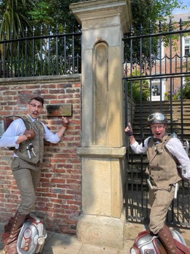 two men in uniform standing next to a brick wall at Highgate House in Whitby