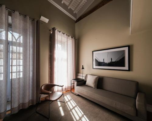 a living room with a couch and a window at Casa do Juncal in Guimarães