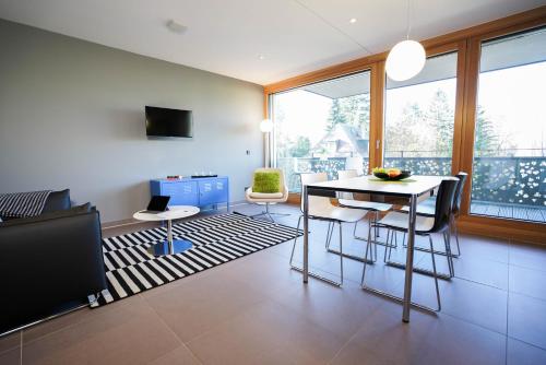 a living room with a table and chairs and a television at Max Lodging Serviced Apartments in Munich