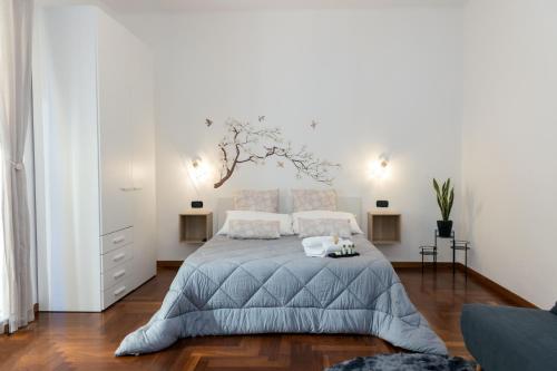 - une chambre avec un lit et un arbre sur le mur dans l'établissement ApuliaLux Prana Home - Bari City Center, à Bari