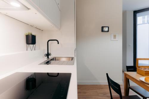 - une cuisine avec un évier et une table dans l'établissement Beauvoir Germain, à Paris