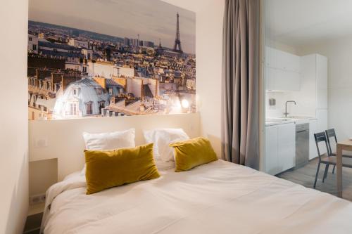 une chambre avec un lit blanc avec des oreillers jaunes dans l'établissement Beauvoir Germain, à Paris