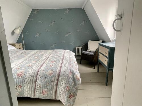 The Old Smoke House في Kent: غرفة نوم بسرير وجدار ازرق