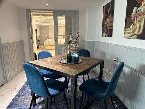 stół jadalny z niebieskimi krzesłami w pokoju w obiekcie Unique Royal Basement residence w Amsterdamie