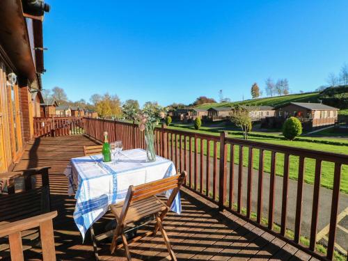a table and chairs on a deck with a fence at The Fairhaven in Richmond