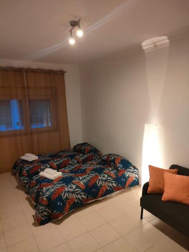 a bedroom with a bed and a lamp and a couch at A place to rest and enjoy in Piedade
