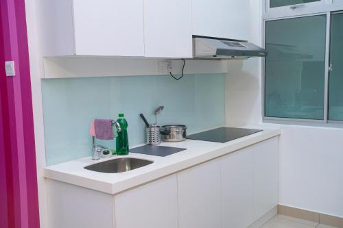 a white kitchen with a sink and a window at Mount Austin Manhanttan Sovo by Cactus Homestay in Johor Bahru