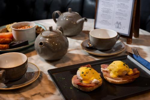 a table with plates of food and cups of coffee at The Temperance Inn, Ambleside - The Inn Collection Group in Ambleside