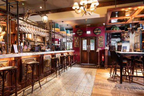 a bar with wooden stools in a restaurant at The Temperance Inn, Ambleside - The Inn Collection Group in Ambleside