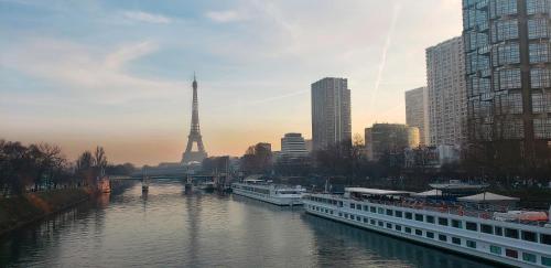 um rio com um navio de cruzeiro e a torre Eiffel em Bateau Botticelli Seine by CroisiEurope em Paris