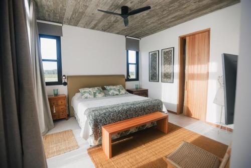una camera da letto con un letto e un ventilatore a soffitto di La MaSia a Balneario Buenos Aires