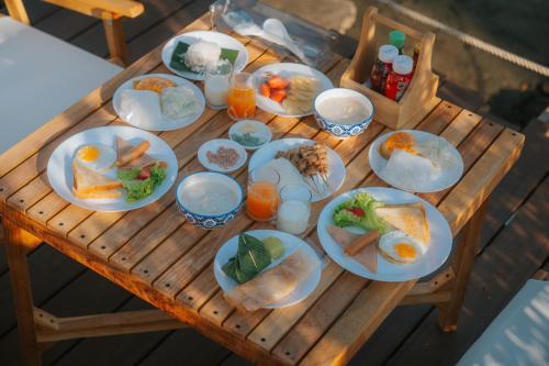 a wooden table with plates of food on it at Sea Sand See Sky Beach Front Resort in Phuket Town