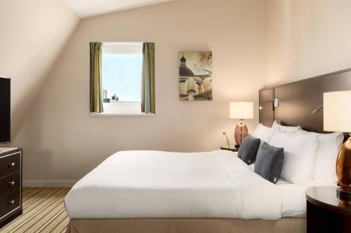 ein Schlafzimmer mit einem großen weißen Bett und einem Fenster in der Unterkunft Renaissance Amsterdam Hotel in Amsterdam