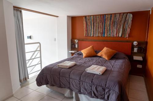 a bedroom with a bed with two pillows on it at Belgrano Decks II in San Carlos de Bariloche