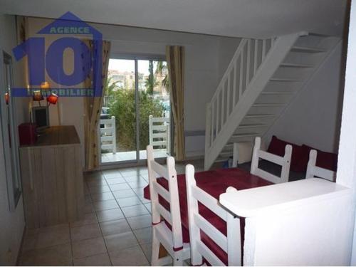 a dining room with a table and chairs and a staircase at Maison Valras-Plage, 3 pièces, 6 personnes - FR-1-781-6 in Valras-Plage