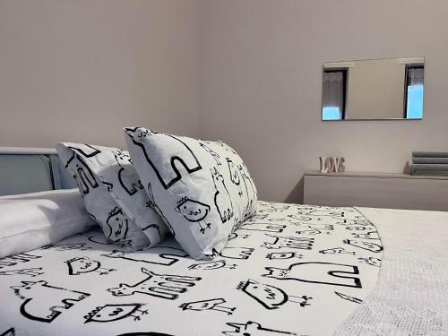 カザーレ・モンフェッラートにあるCasa Piemontのベッド(白黒のシーツ、枕付)
