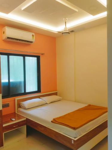 新孟買的住宿－SAHIL STAY Inn，一间卧室设有一张床、一个窗口和风扇