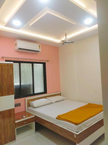 a bedroom with a bed and a window and a air conditioner at SAHIL STAY Inn in Navi Mumbai