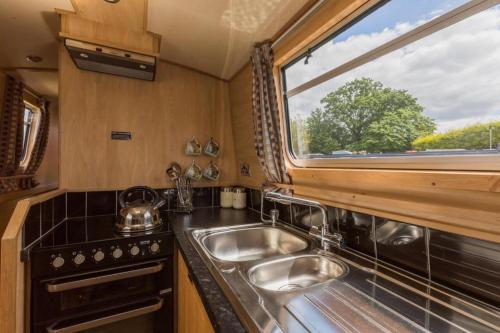 a kitchen with a sink and a window at Wren Class at Gayton Marina in Northampton