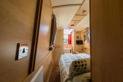 a small room with a bed and a mirror at Wren Class at Gayton Marina in Northampton