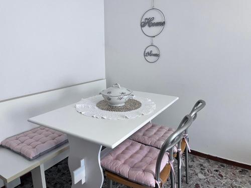 a white table with pink chairs and a tea pot on it at Casa Piemont in Casale Monferrato