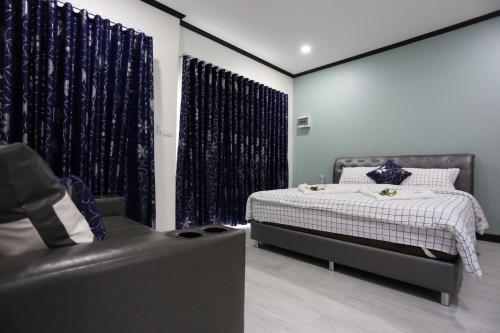 a bedroom with a bed and a chair and curtains at MB House in Ban Nai Rai