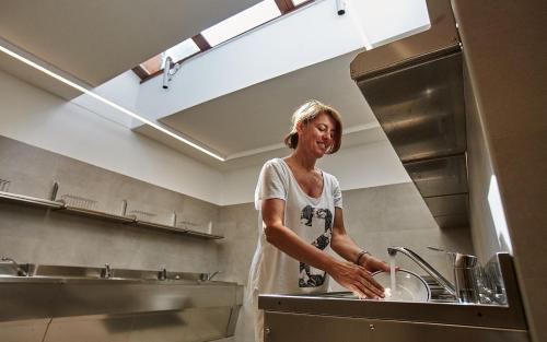 a woman standing in a kitchen preparing food at Dei Fiori Camping Village in Cavallino-Treporti